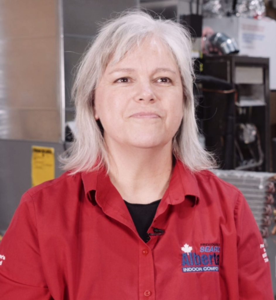 Carla, co-owner of Alberta Indoor Comfort and an Aging-in-Place Specialist, in a red company shirt