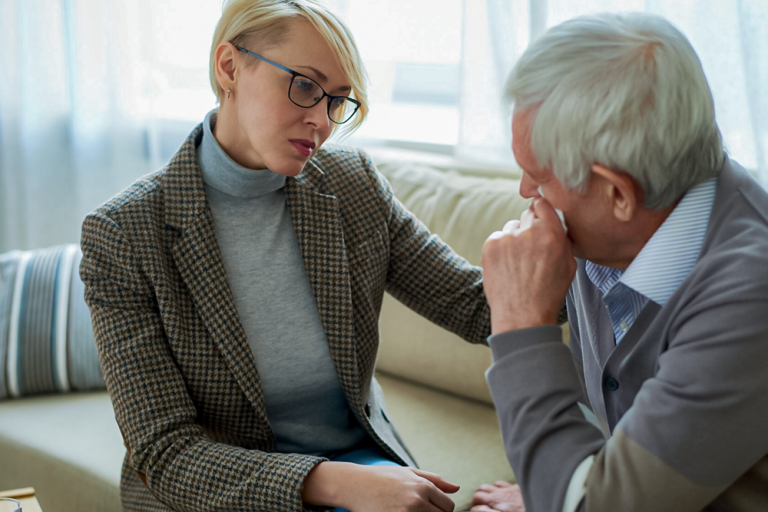 An adult daughter talking with her father at home