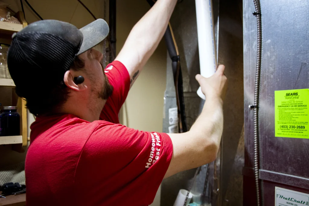 Double furnace installation crew removing an old furnace in a Calgary home