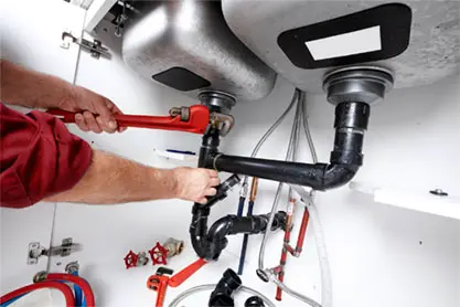 Plumbing technician working on home piping