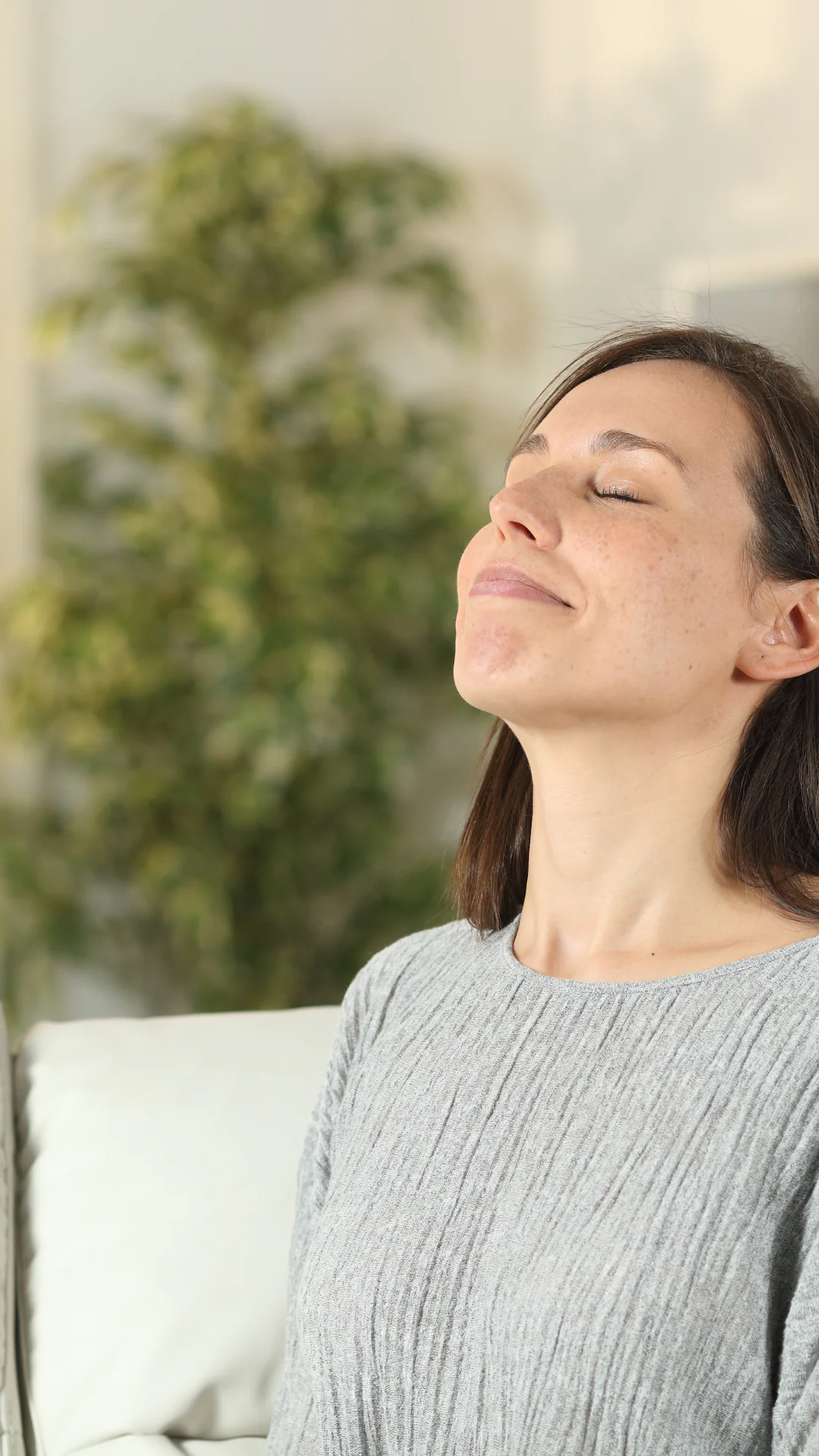 calgary_woman-enjoying-new-ac-in-home calgary woman relaxing inside her om on the couch due to ac unit newly installed